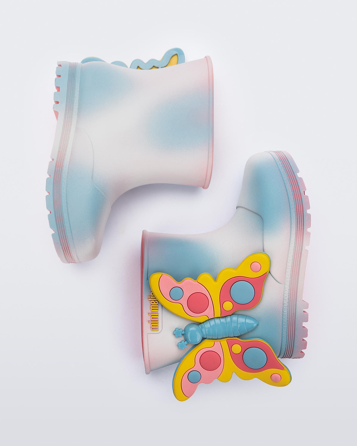 side view of a pair of pink with blue splotches Welly Wonderland baby boot with yellow/blue butterfly on side