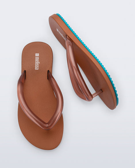 Top and side view a pair of brown Flip Flop Airflow sandal with a clear brown strap and blue bottom
