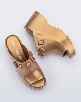Top and side  view of a pair of metallic gold Patty Stones + Undercover platform open toe mules with beige sole and stone embellishments on upper.