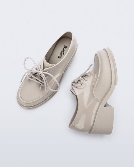 Side and top view of a pair of beige Tailor loafers