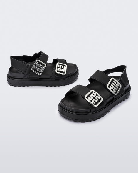 Side and front angled view of a pair of black Towny sandals with straps and silver buckle