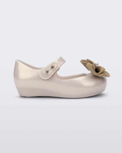 Side view of a beige Ultragirl Sweet baby ballerina flat with bow