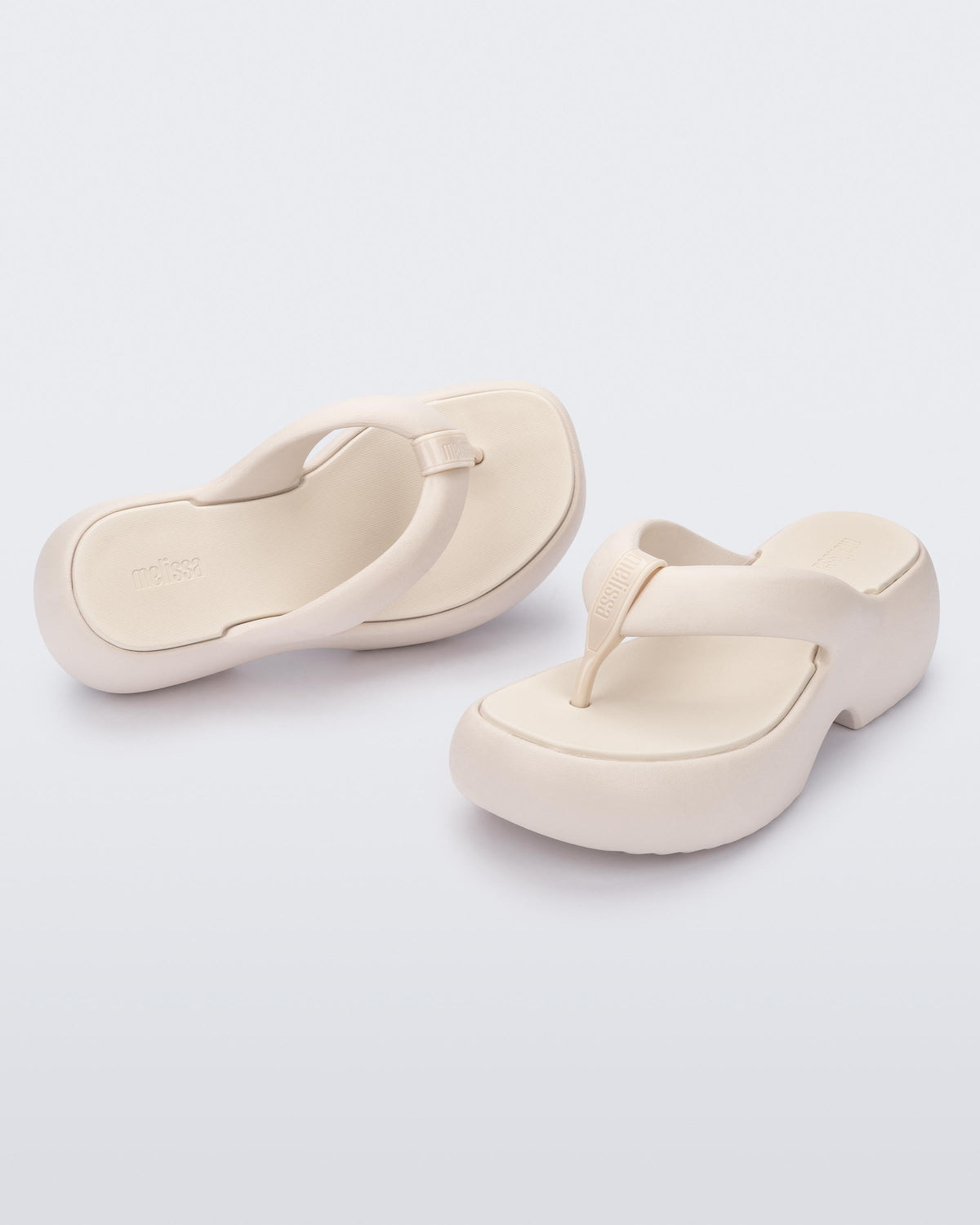 Top and angled view of a pair of beige Free Platform II flip flops