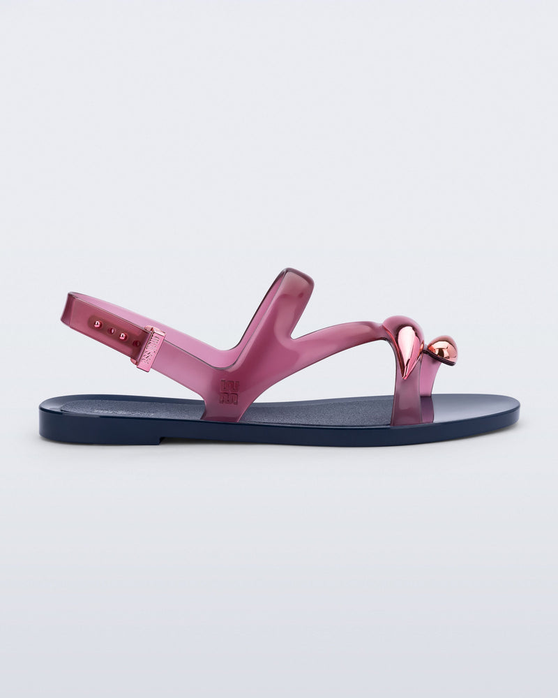 Side view of an pink  Iris sandal with blue sole and rose gold upper embellishments