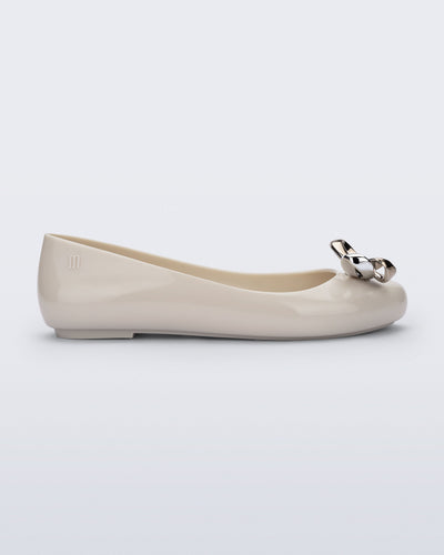 Side view of a beige Sweet Love Glam ballerina flat with chrome bow