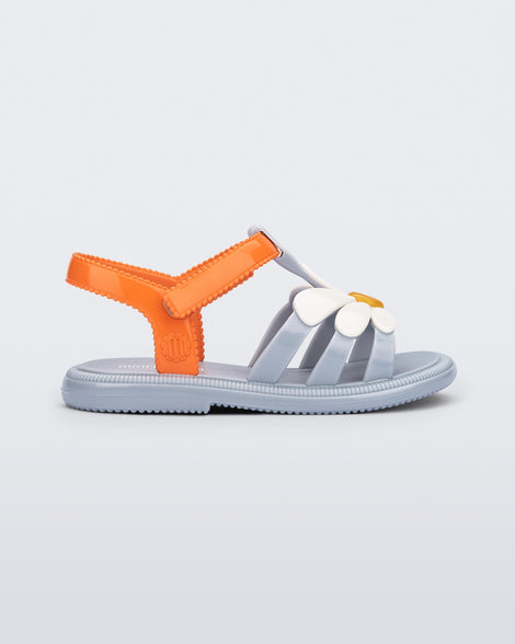 Side view of a blue baby Hip Bloomy sandal with orange strap and white flower