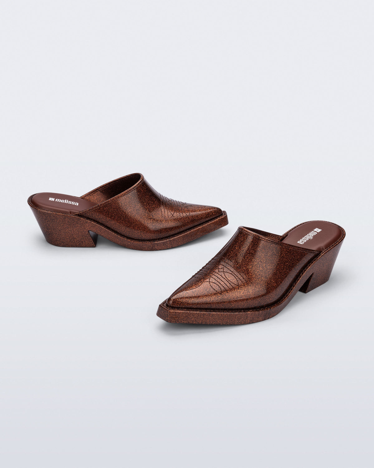 Side and angled view of a pair of bronze glitter Texas Mule heels
