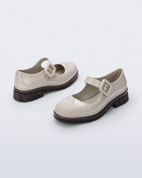 Back and side angle view of a pair of beige with brown sole June mary janes with matte toe cap