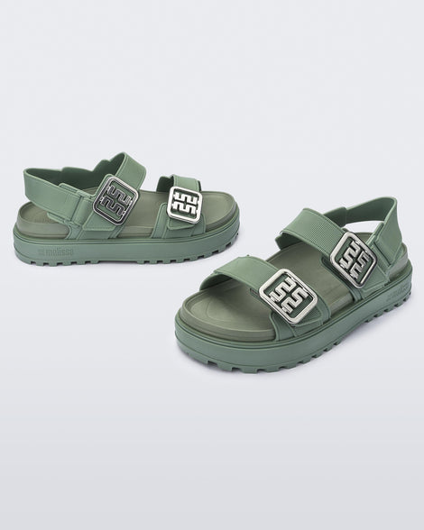 Side and front angled view of a pair of green Towny sandals with straps and silver buckle