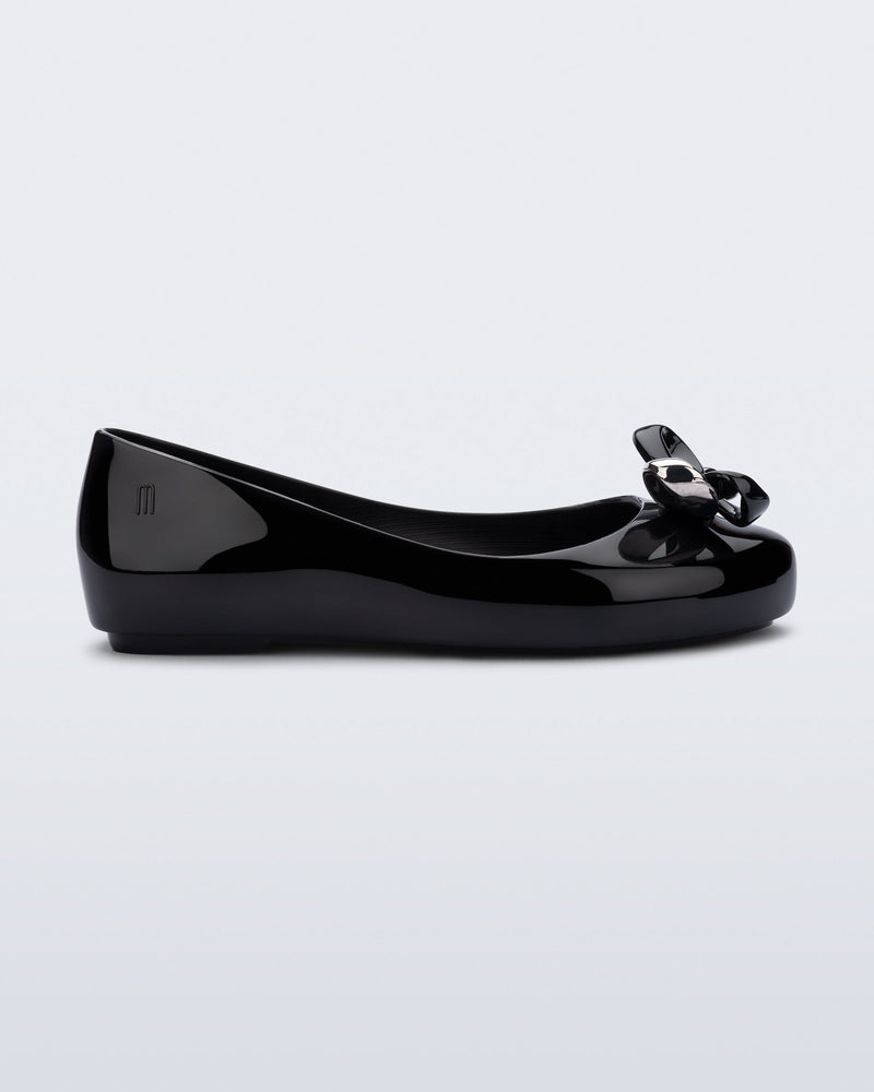 Side view of a black Sweet Love Glam kids ballerina flats with bow