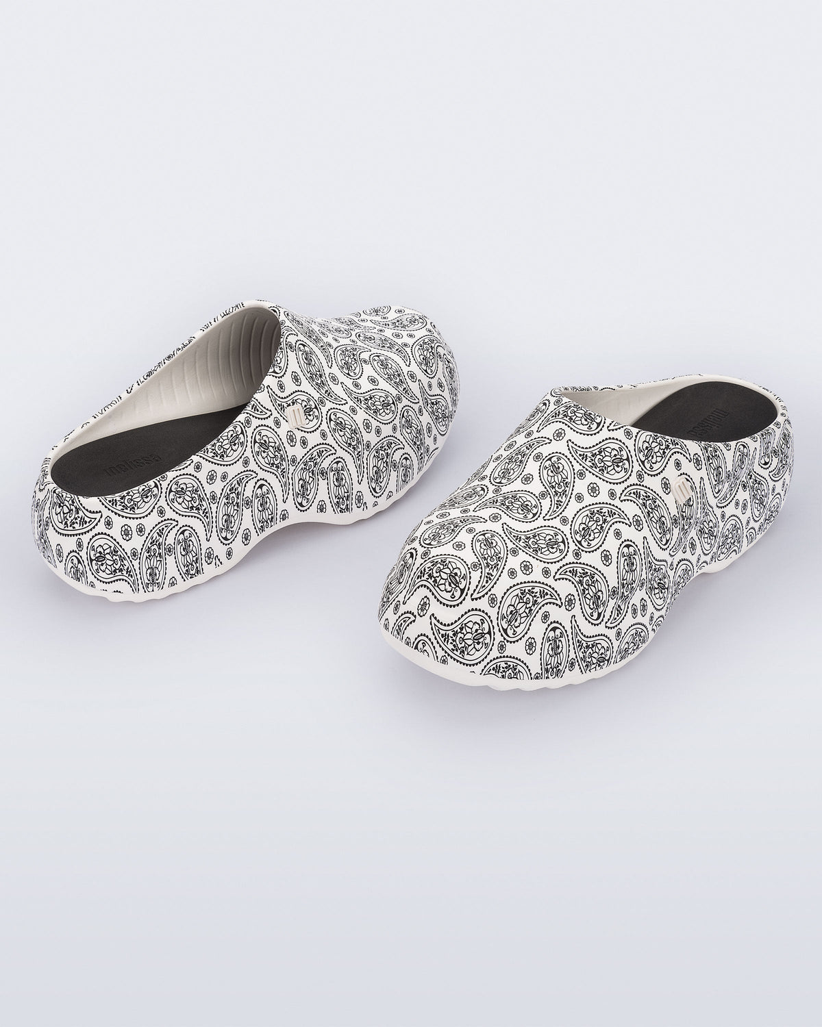 Front and back angled view of a pair of white print Free Clog Print platforms with black paisley print