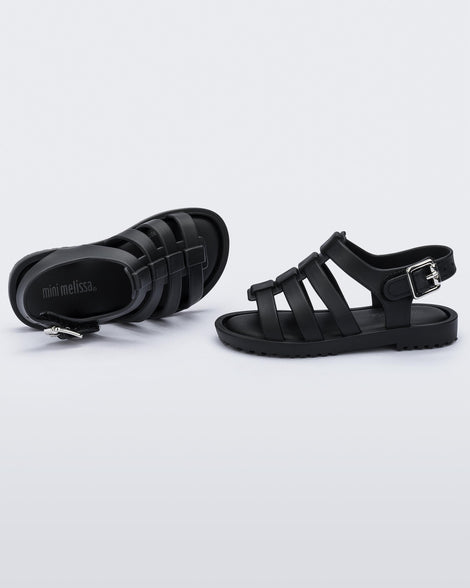 A top and side view of a pair of black Mini Melissa Flox sandals with straps.