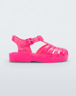An outter side view of a pink Mini Melissa Possession sandal with several straps and a closed toe front.