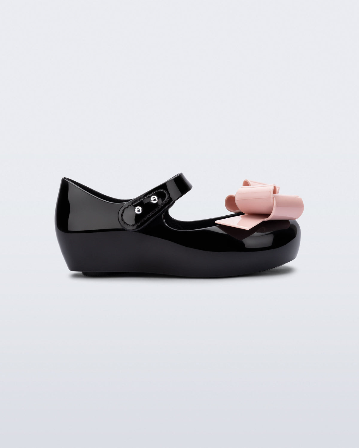 Side view of a black Ultragirl Classy baby ballerina with pink bow.