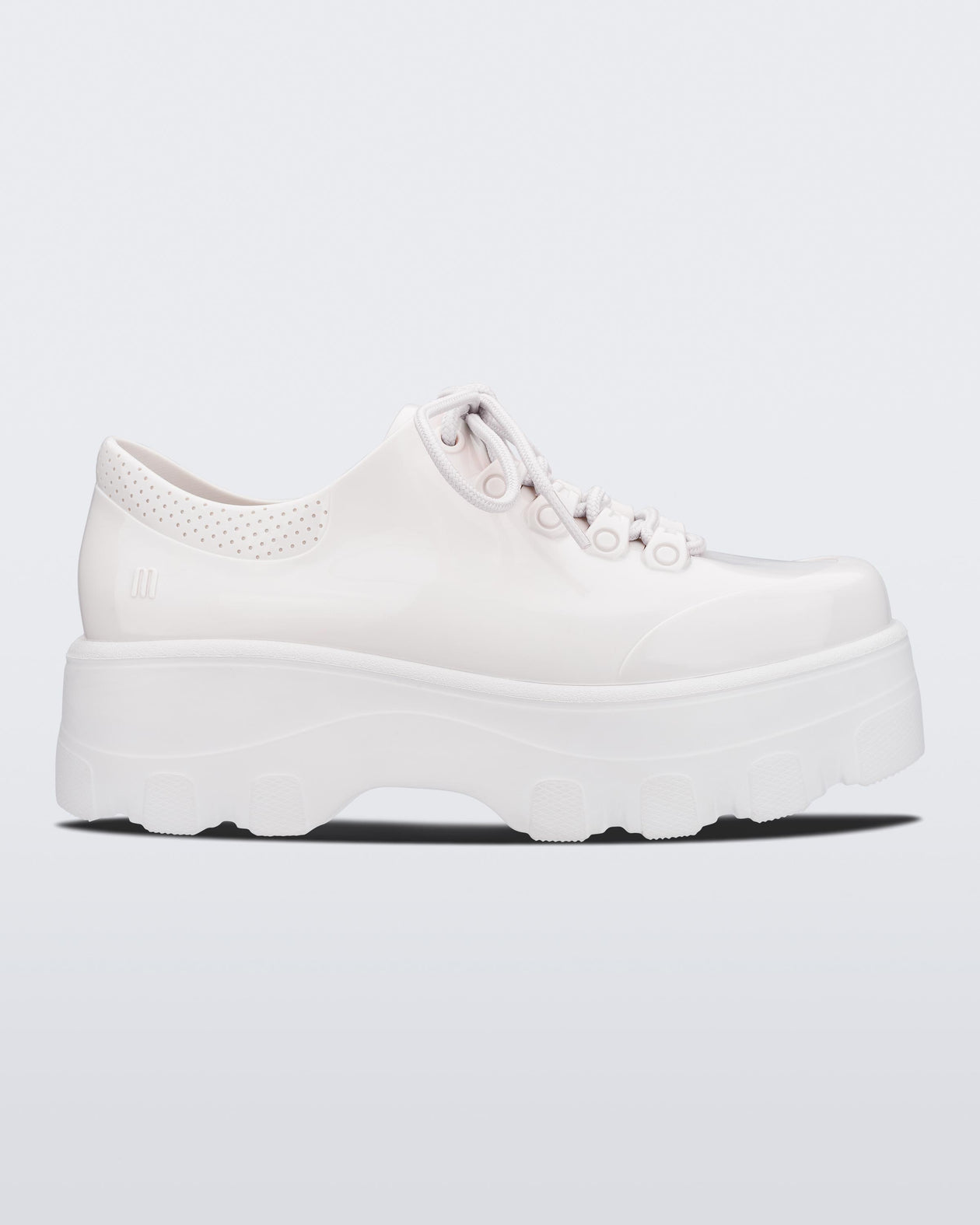 Side view of Melissa Kick Off platform sneaker in white. The sneaker has traditional white tie up laces.