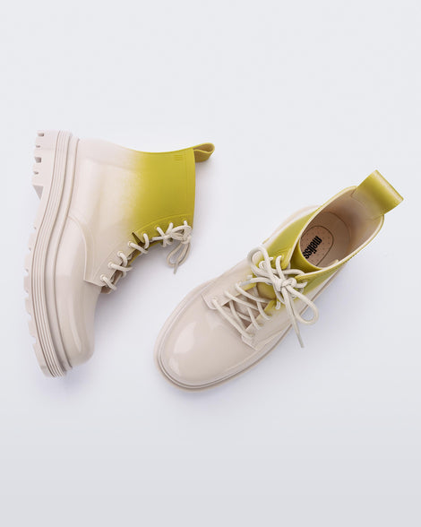 A top and side view of a pair of beige/green Melissa Coturno boots with a green into beige ombre base, beige laces and sole.