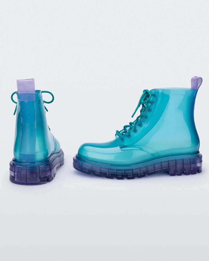 A back and side view of a pair of clear lilac/blue Melissa Coturno boots with a transparent blue base, laces and a lilac sole.