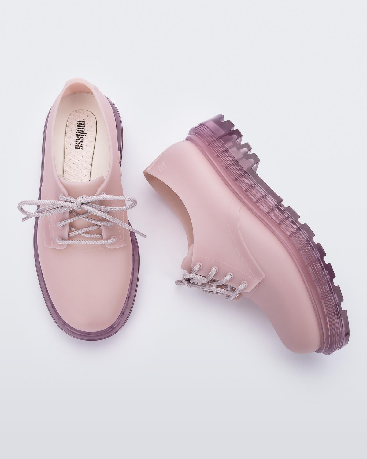 A top and side view of a pair of matte lilac Melissa Bass sneakers, with a light matte lilac base, lilac laces and a darker transparent lilac sole.