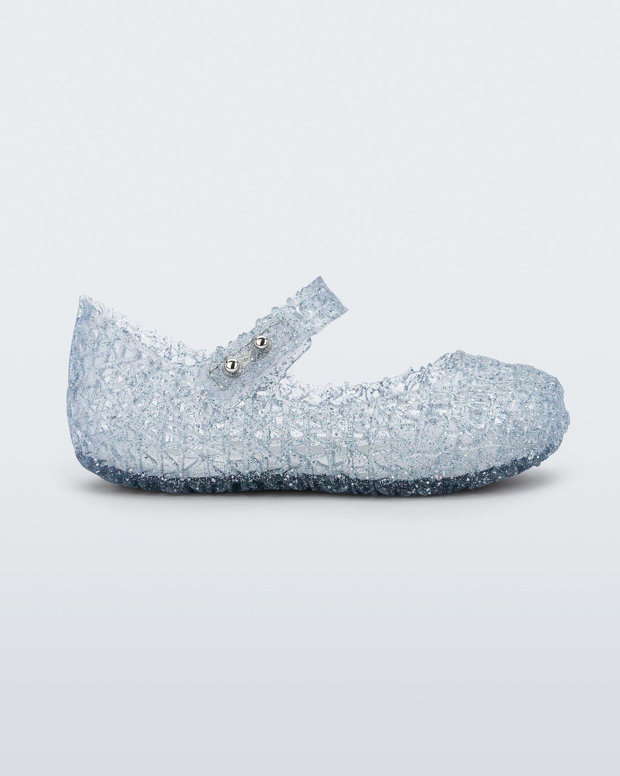 Side view of Mini Melissa Campana clear glitter flats with a snap strap for baby with an open woven texture
