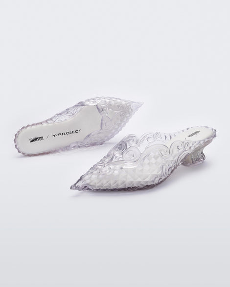 An angled front and top view of a pair of clear white Melissa Court heels with a heart detail on the front and a checkered pattern texture.