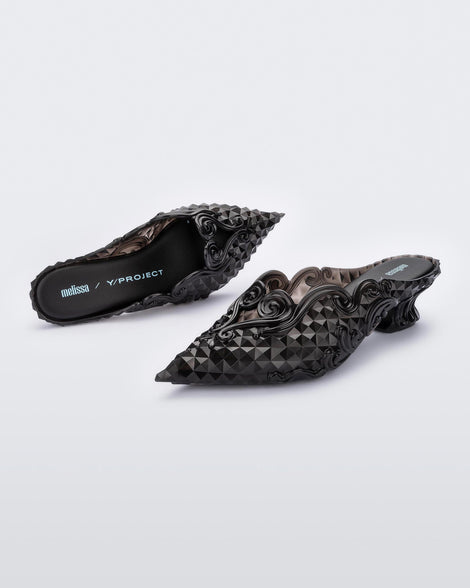 An angled front and top view of a pair of clear black Melissa Court heels with a heart detail on the front and a checkered pattern texture.