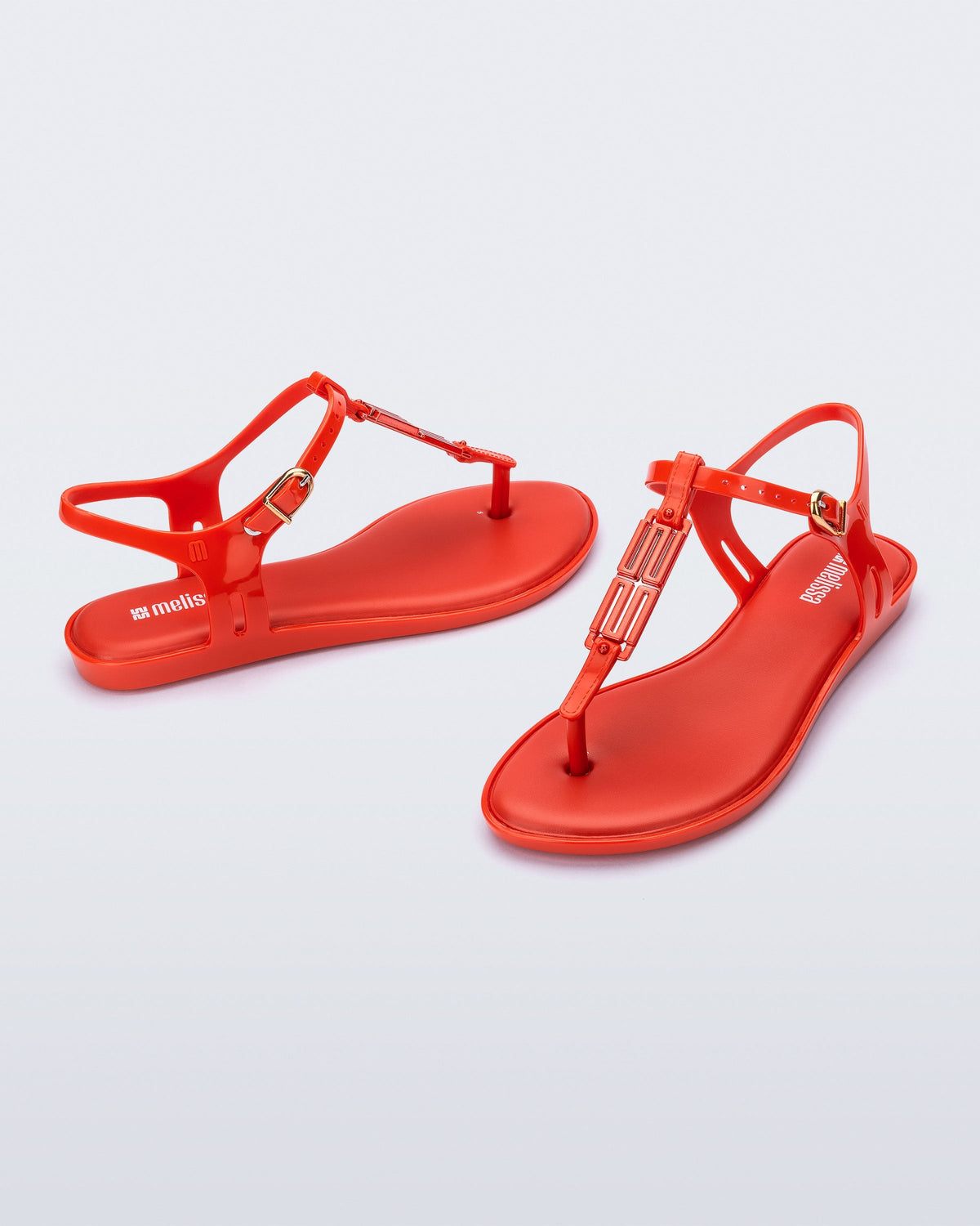 Side and front view of a pair of red Solar M Chic sandals with red embellishment