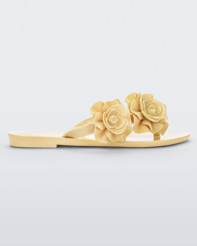Side view of a yellow Melissa Harmonic Garden flip flop with flowers on the straps.