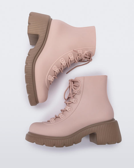 A side view of a pair of brown/pink Melissa Cosmo boots with a pink base, laces and a brown heel sole, laying on their side.