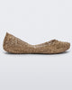 Side view of a gold Melissa Campana flat with an open woven texture.