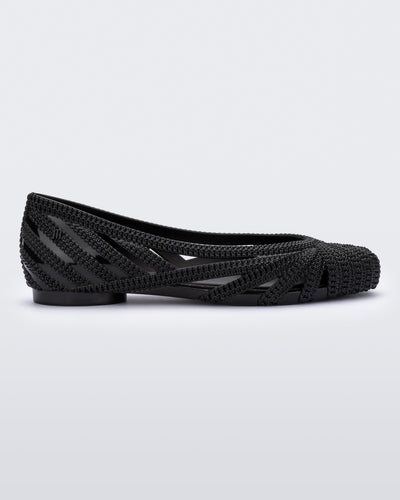 Side view of a black Melissa Femme Classy flat with a woven design.