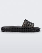 Side view of a transparent black Melissa Court Slide with a checkered pattern texture.