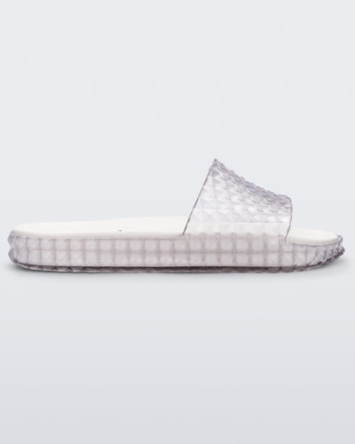Side view of a clear/white Melissa Court Slide with a checkered pattern texture.