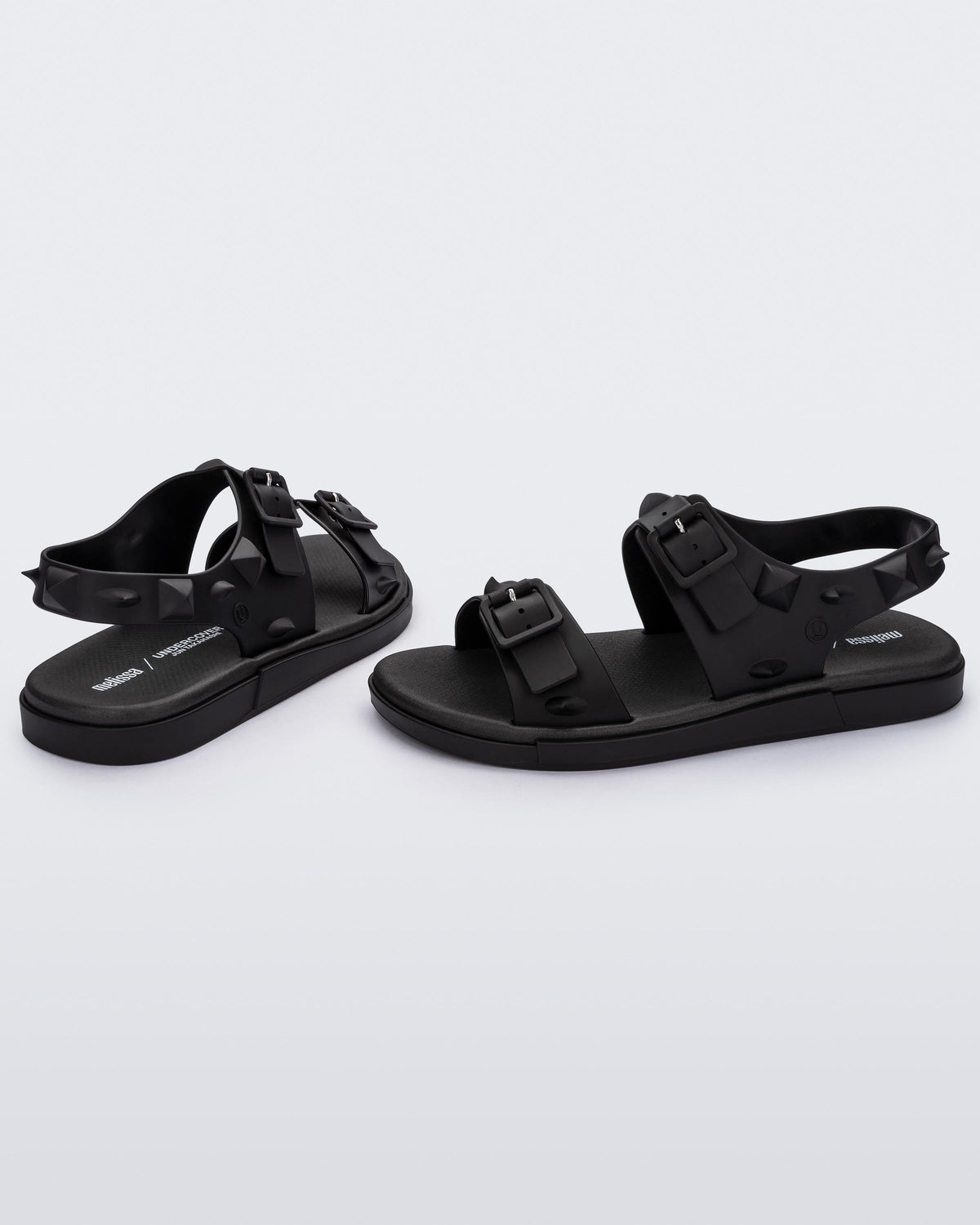 A side and back view of a pair of black Melissa Spikes Sandals with two straps with buckles on top and spike details around the base.