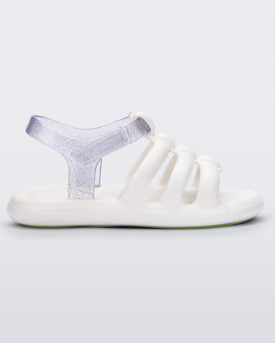 Side view of a white Mini Melissa white sandal with white and clear glitter straps.
