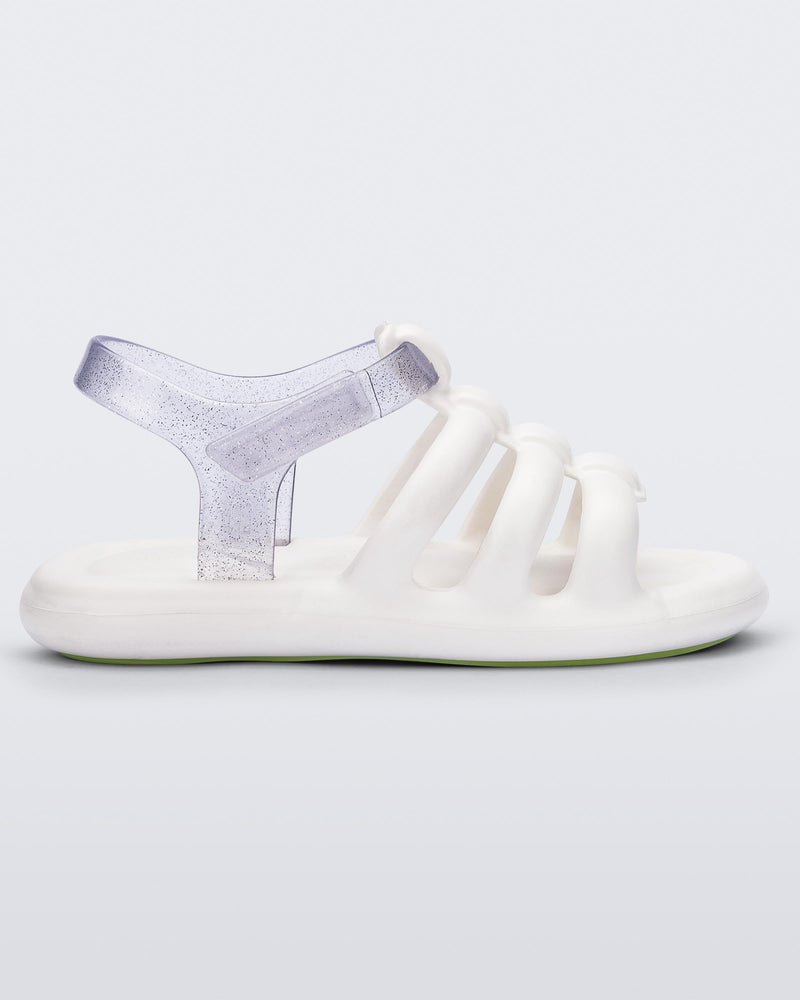 Side view of a white Mini Melissa white sandal with white and clear glitter straps.