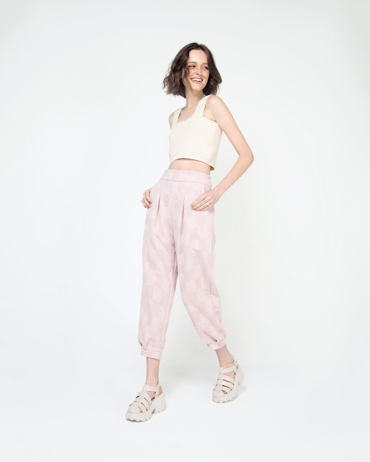A model posing wearing a pair of beige Melissa Megan platformm heel sandals.