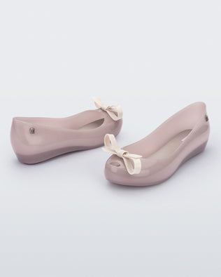 Back and angled view of a pair of beige Ultragirl Bow flats.