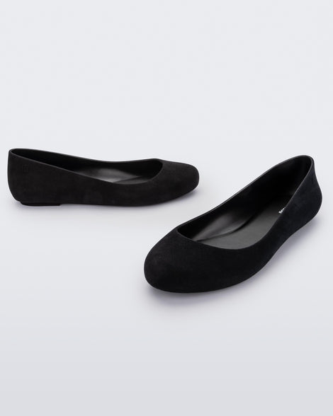 Angled view of a pair of black flocked Melissa Sweet Love Basic Velvet flats.