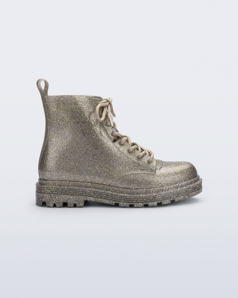 Side view of a Mini Melissa lace up Coturno boot in gold glitter color-way