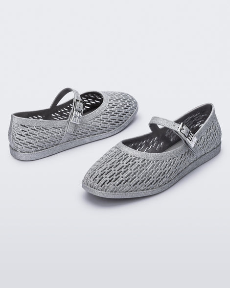 Top and angled view of a pair of silver glitter Harper flat with strap