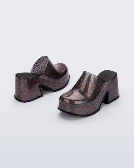 Side and back angled view of a pair of mixed glitter Mia mules with black sole