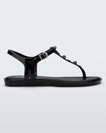 Side view of a black Melissa Solar studs sandal with gold studded t-strap and gold buckle.