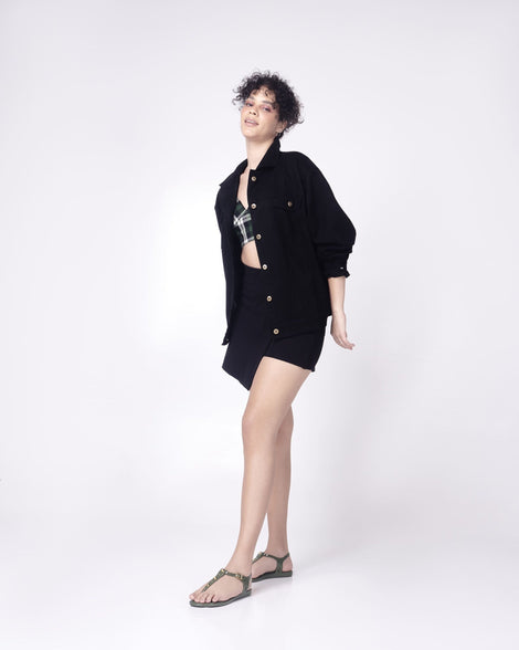 Model in a black outfit wearing  a pair of green Melissa Solar studs sandals with gold studded t-strap and gold buckle.