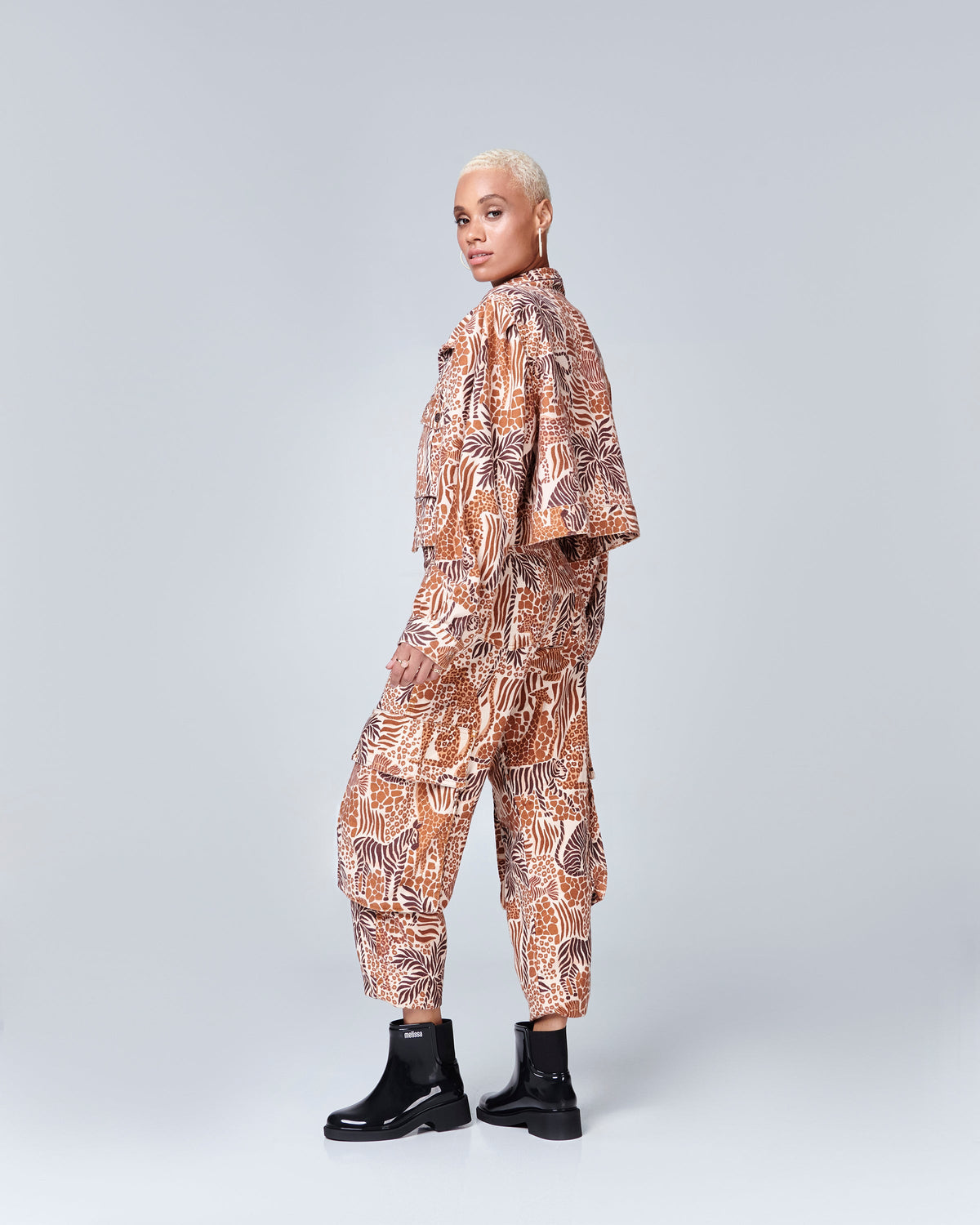 Model in a patterned pant suit wearing a pair of black Chelsea Boots.