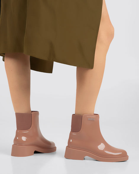 Model's legs wearing a pair of brown Chelsea Boots.