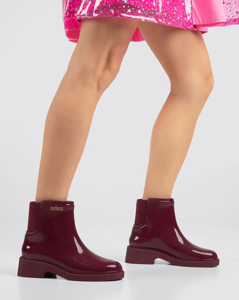Model's legs wearing a pair of burgundy red Chelsea Boots.