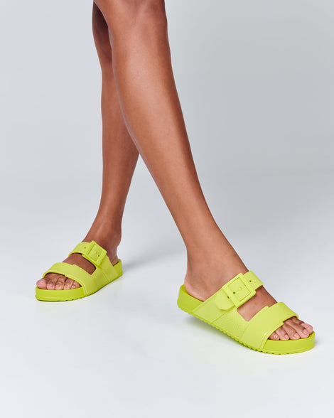 Model's legs wearing a pair of green Cozy Connection slides
