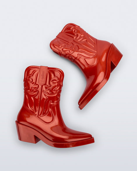 Side view of a pair of red Texas boots with pointed toe. 
