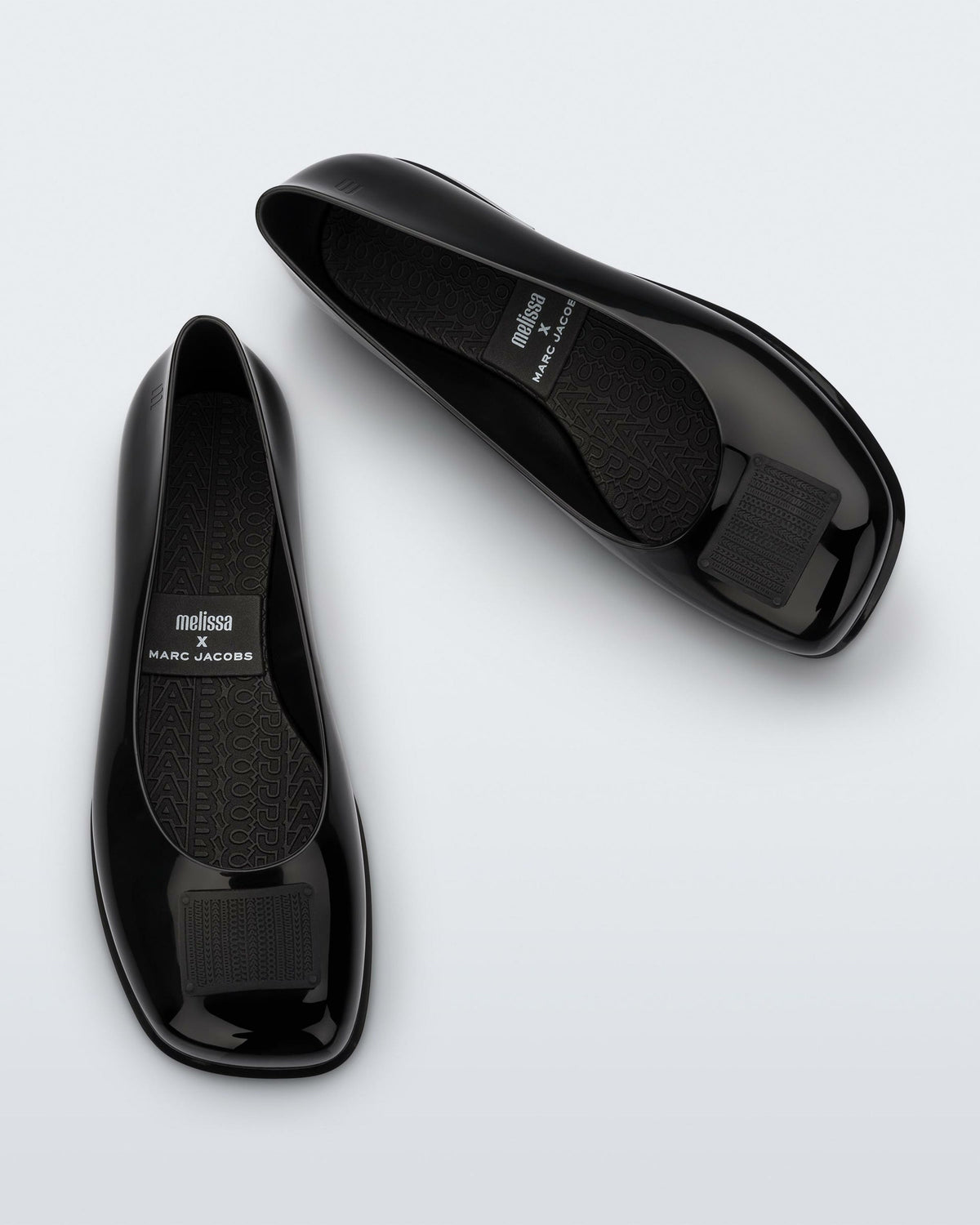 Side and angled view of a pair of black Ruby + Marc Jacobs flats