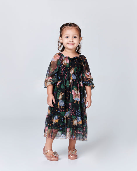 Child model in a black butterfly dress wearing a pair of gold Sweet Love Butterfly baby flats